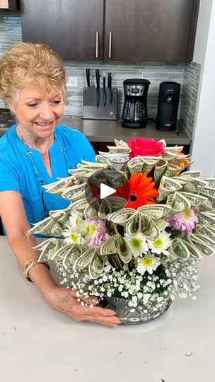 a woman is holding a bouquet of flowers in her hands while sitting at the kitchen counter