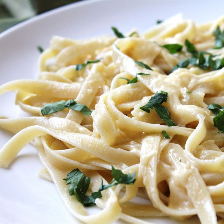 a white plate topped with pasta and parsley