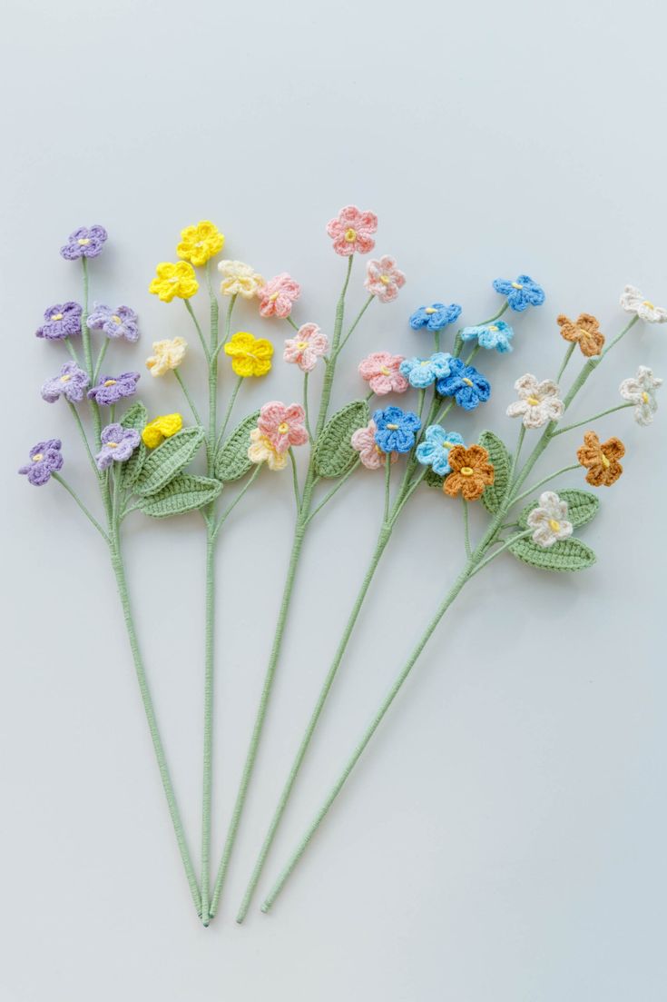 small crocheted flowers arranged on top of each other in different colors and sizes