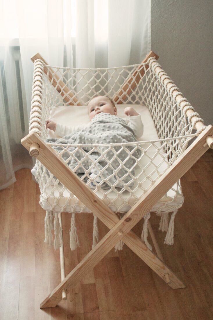 a baby is laying in a hammock on the floor