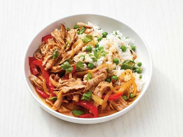 a white bowl filled with rice, meat and veggies on top of a table