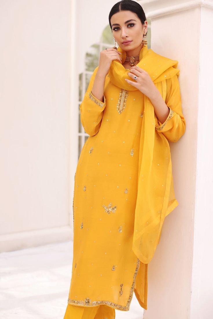 A festive mustard yellow pure raw silk long kameez with gold and antique hand craftmenship done by our expert artisans. Accompanied by a detailed zari border on straight trousers alongside pure organza dupatta with sequins spray and gotah edging, this regal design makes the perfect look for mehndis, dholkis, baraat and Diwali Gold Embroidery Straight Kurta Salwar Kameez, Diwali Salwar Kameez With Gold Embroidery, Diwali Gold Embroidery Straight Salwar Kameez, Chanderi Salwar Kameez With Gold Embroidery, Gold Unstitched Palazzo Set With Straight Kurta, Gold Dola Silk Palazzo Set With Resham Embroidery, Gold Palazzo Set With Zari Work For Festive Occasions, Designer Gold Dola Silk Palazzo Set, Gold Dola Silk Palazzo Set For Designer Wear