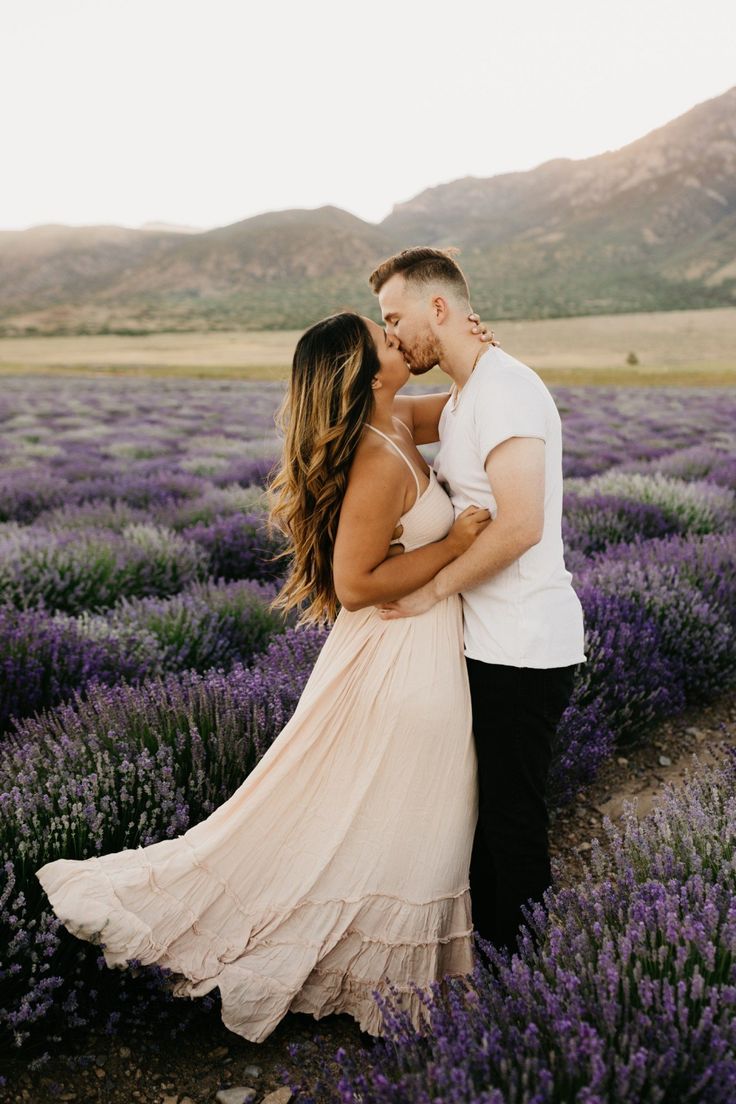 a man and woman standing next to each other in a lavender field