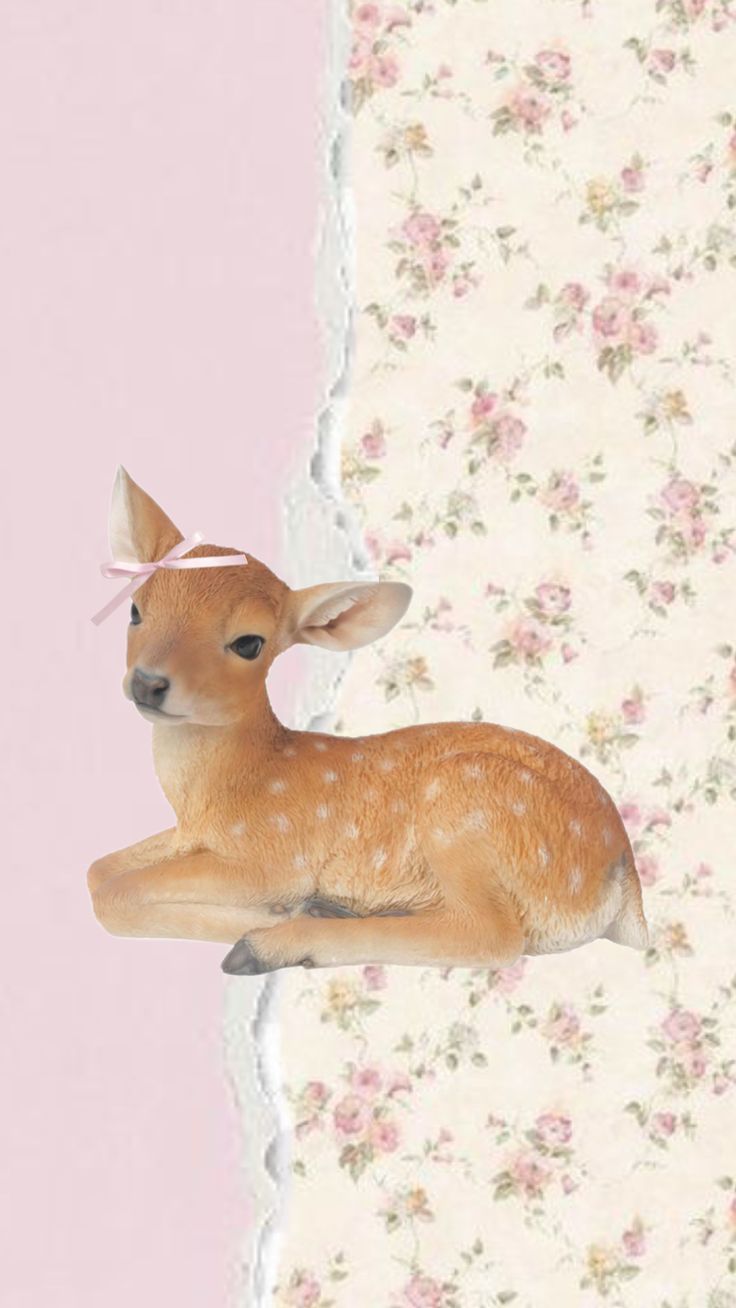 a small deer laying on top of a table next to a flowered wallpaper