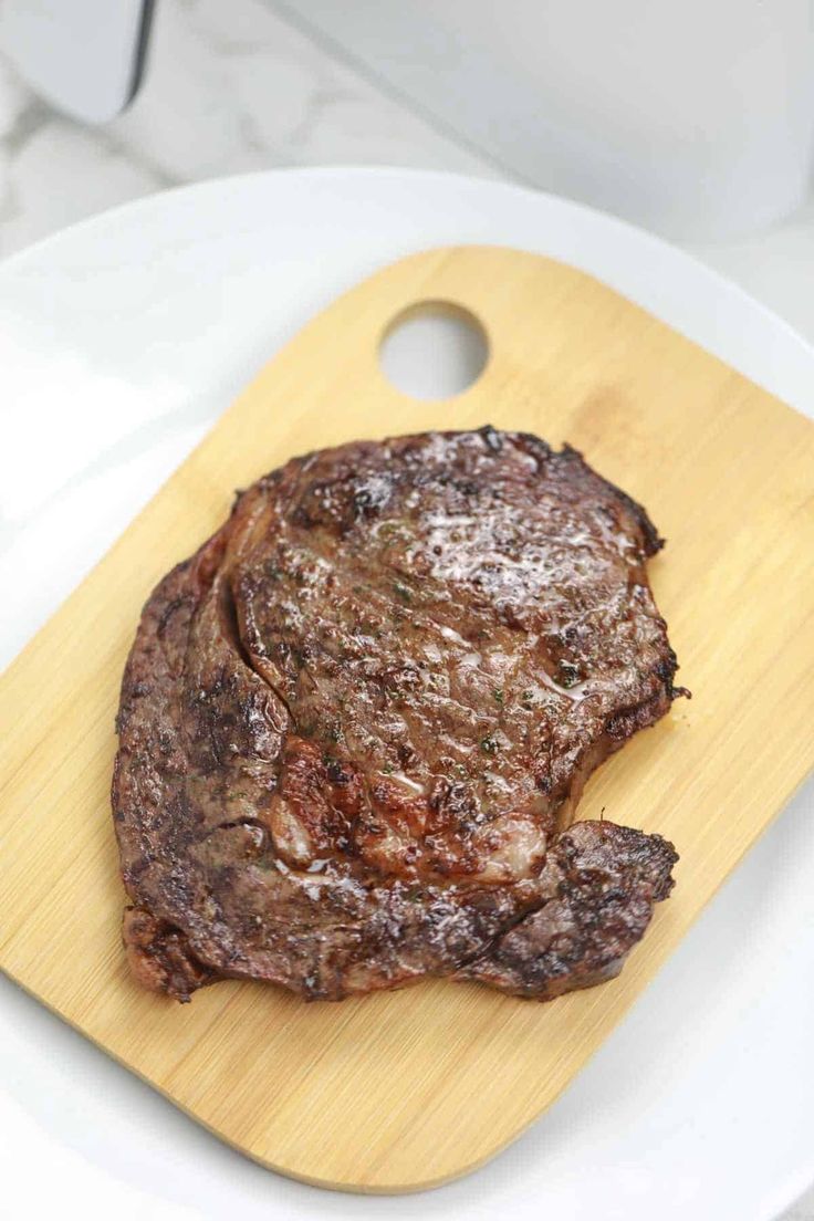 a piece of steak on a wooden cutting board