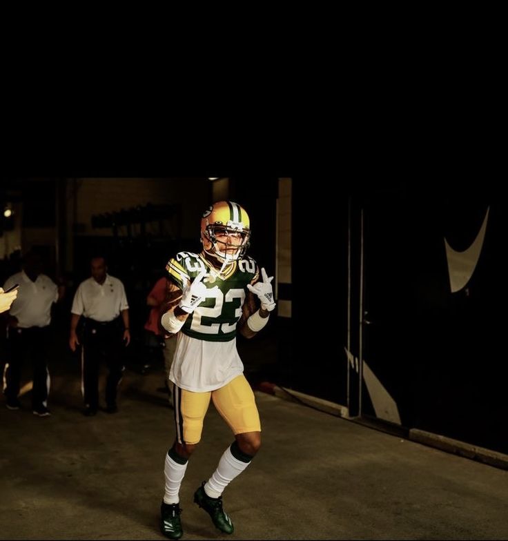 a green bay packers football player is walking out of the tunnel with his helmet on