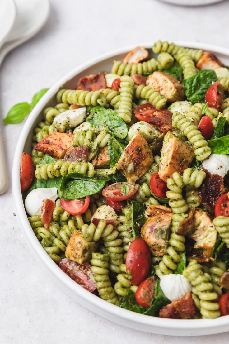 a white bowl filled with pasta salad on top of a table