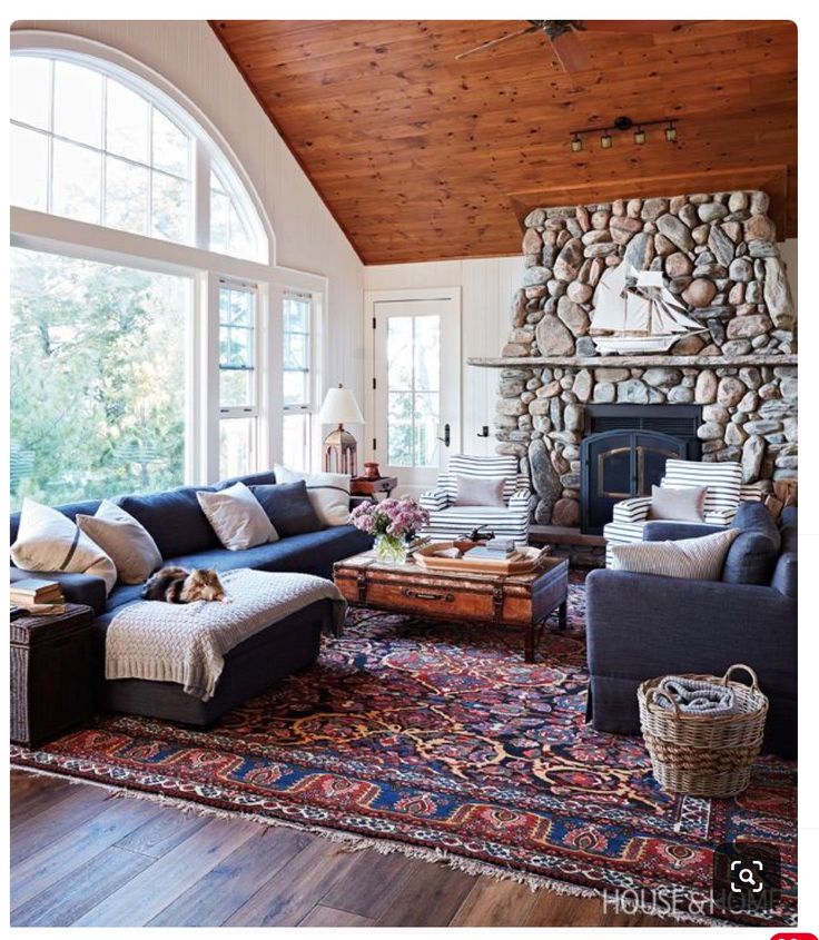 a living room filled with lots of furniture and a fire place in the middle of it