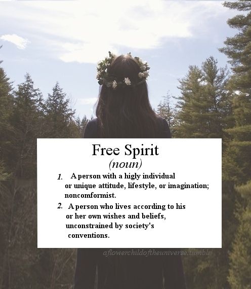 a woman standing in front of trees holding a sign with the words free spirit on it