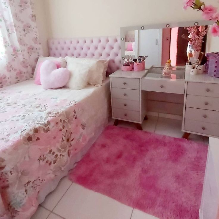 a bedroom with pink carpet, white furniture and flowers on the bedding is shown