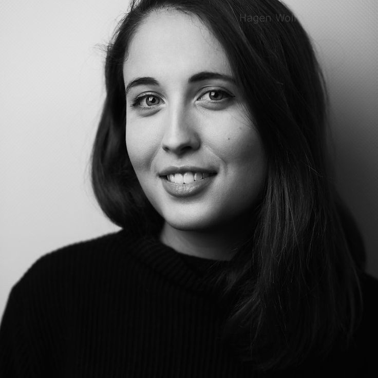 a black and white photo of a woman with long dark hair smiling at the camera