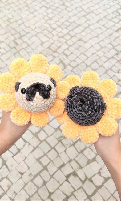 two crocheted sunflowers with a small black and white dog on them