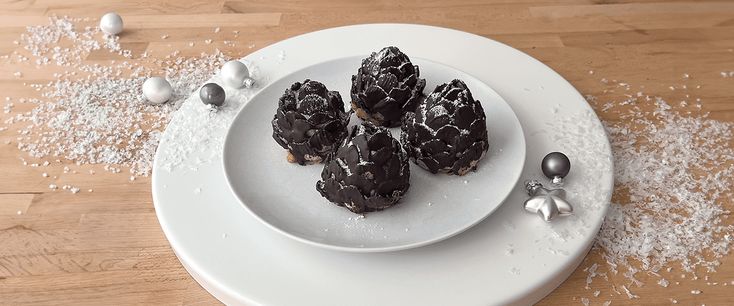 a white plate topped with chocolate covered donuts and sprinkles on top of a wooden table