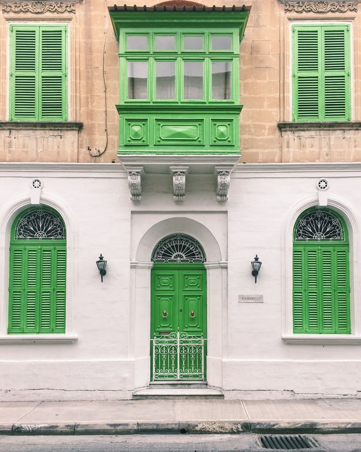 an old building with green doors and windows