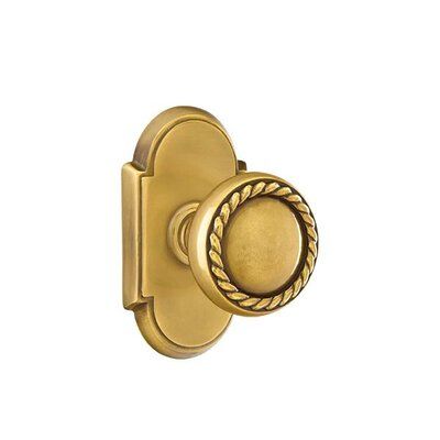 an antique brass door handle with roped handles and round knob on the outside of it