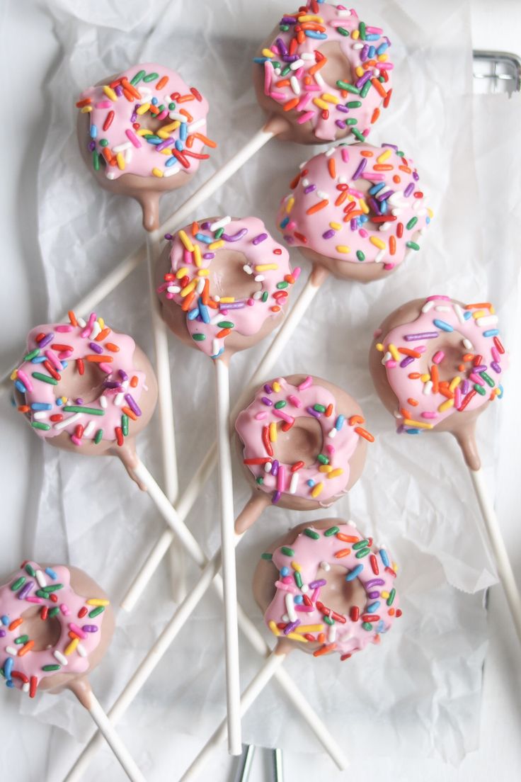 there are many donuts with sprinkles on the sticks in the box