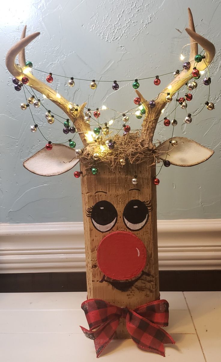 a wooden box with reindeer's head and lights on it