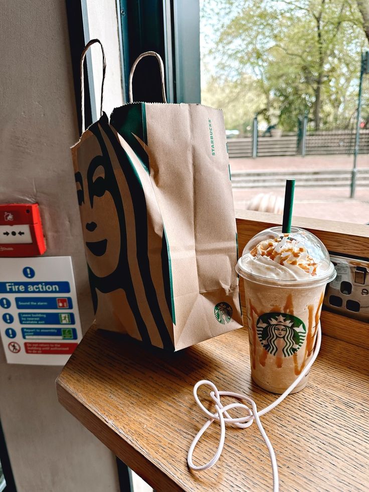 there is a starbucks drink and a bag on the table