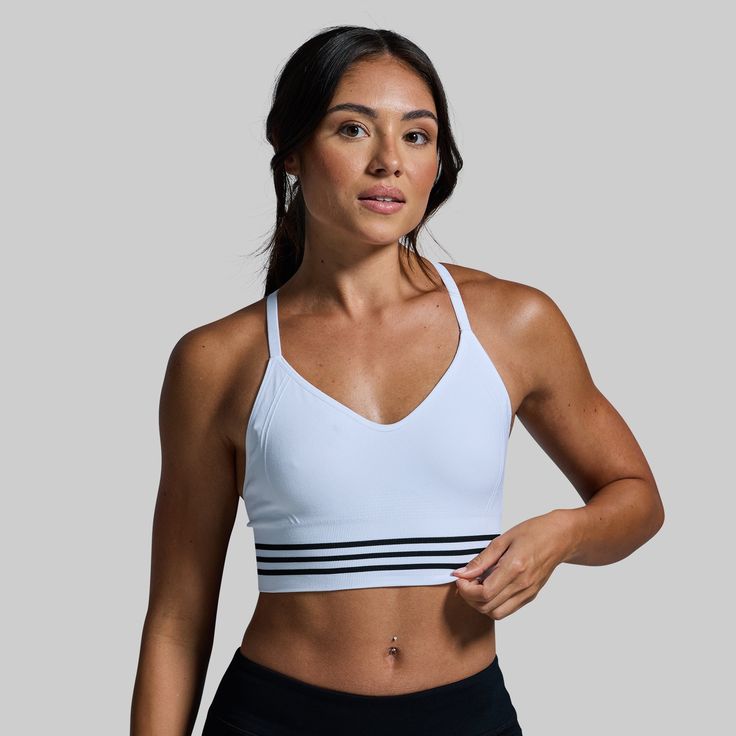 Our Level Up Sports Bra was created to truly feel like a second skin. To deliver just that, we started with a seamless design that delivers unmatched comfort while hugging your body without restricting your movement. Then, we used a moisture-wicking and breathable fabric to keep you comfortable when working up a sweat and finished it off with an extended body for added coverage when wearing on its own. Athletic Fit Activewear With Built-in Bra For Training, White Seamless Stretch Activewear, White Fitted Activewear For Gym, Fitted White Activewear For Gym, White Seamless Fitted Sports Bra, Supportive White Sports Bra For Yoga, White High Stretch Activewear For Running, White Sporty Activewear With Built-in Bra, White Athleisure Activewear For Workout