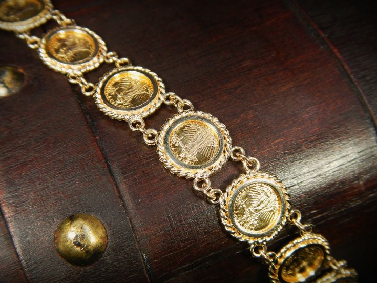 "This exquisite vintage bracelet comes with an appraisal card from North American Gem Lab of Bellevue Washington appraising for $2,700.00. It features 10 Saint-Gaudens double eagle replica coins dated 1914. This bracelet is in excellent condition! The bracelet is hallmarked 14k and measures 13mm wide by 7\" long. Items $100 or more are shipped in a velvet gift box. Items less then $100 will be shipped in a cardboard box with tissue and a fabric ribbon, ready for gift giving or just for safekeepi Antique 14k Stamped Gold Bracelet, Antique Gold Bracelet Stamped 14k, Elegant Ceremonial Coin Jewelry, Heirloom Gold Bracelet Hallmarked, Heirloom Gold Bracelet Stamped 14k, Formal Antique Gold Jewelry Stamped 14k, Antique Ceremonial Gold Jubilee Bracelet, Antique Gold-tone Bracelets For Gift, Vintage Yellow Gold Jewelry With Historical Design