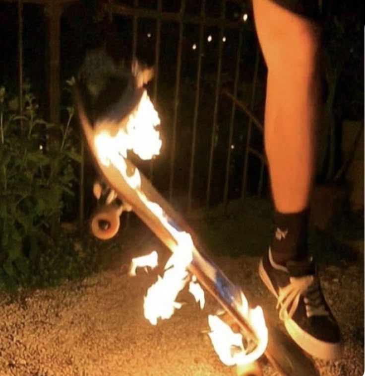 a person on a skateboard with flames coming out of the bottom part of it