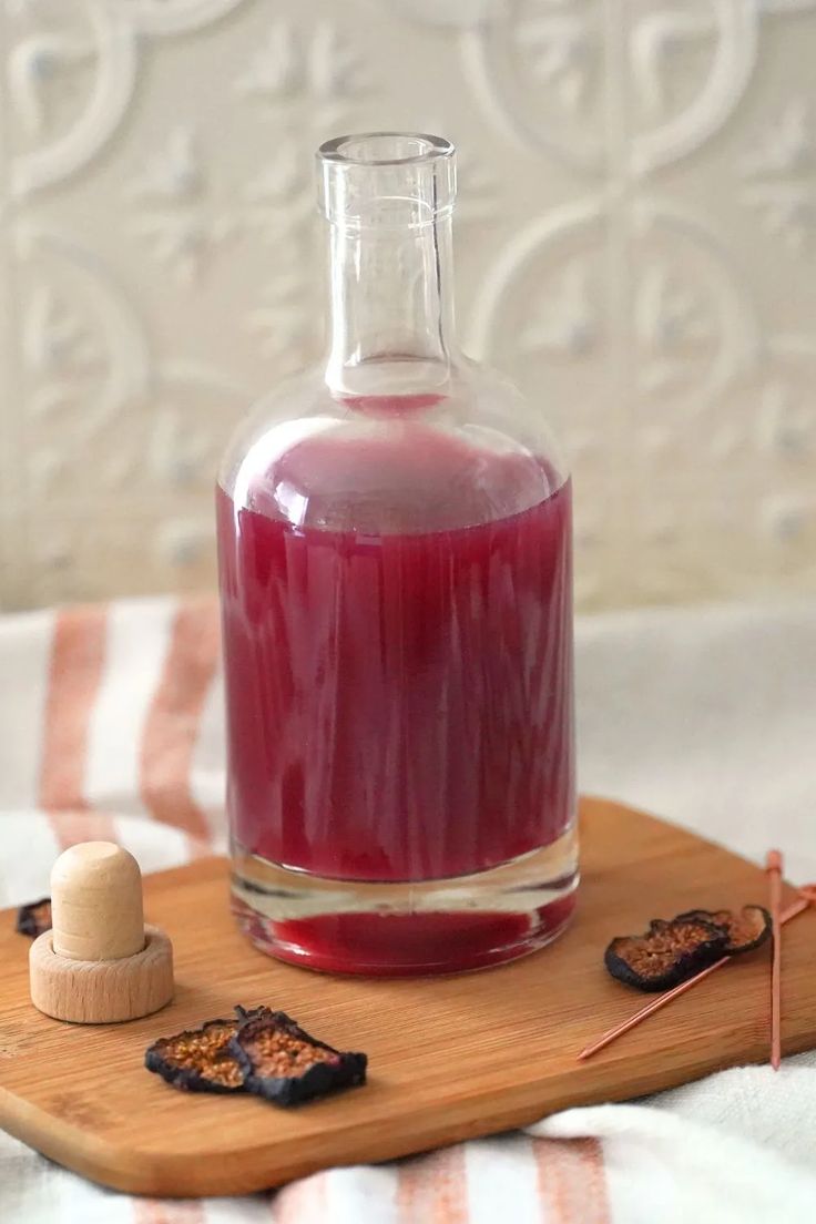 a glass bottle filled with liquid sitting on top of a wooden tray