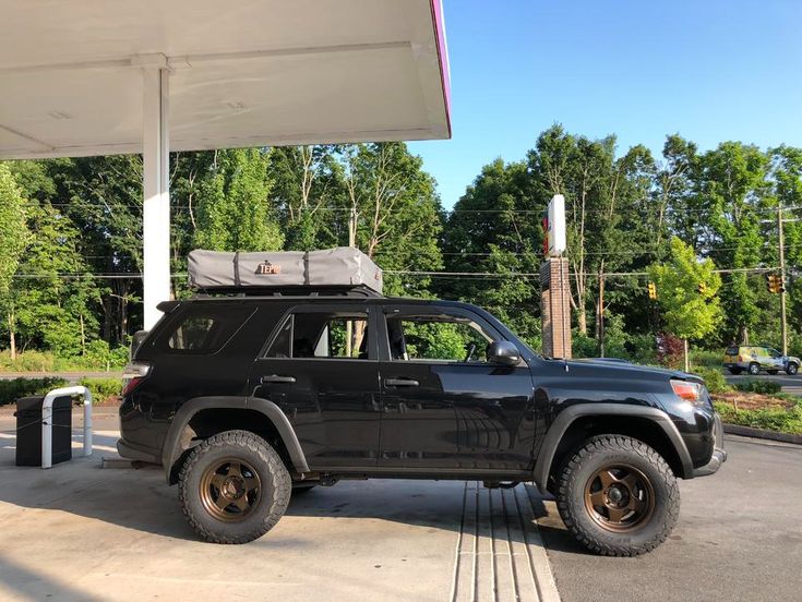 a black jeep parked at a gas station