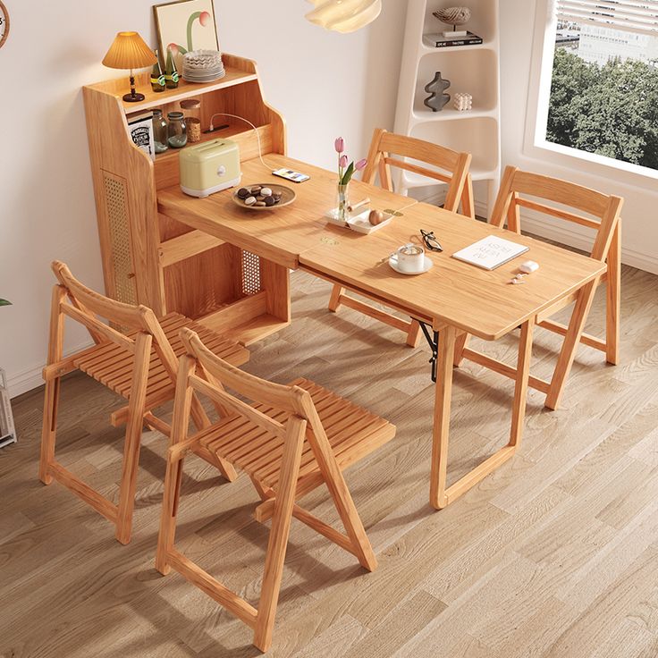 a wooden table and chairs in a room with hardwood floors, white walls and windows