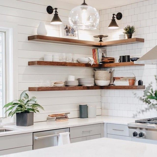 a kitchen with open shelving and hanging lights