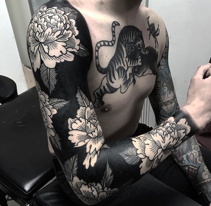 a man with tattoos on his arm and chest