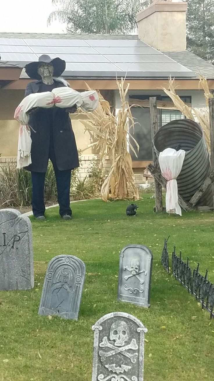 a cemetery with tombstones, headstones and scarecrows in front of it