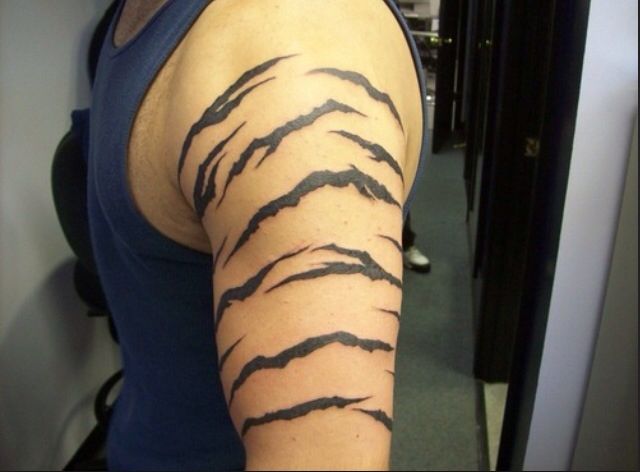 a woman's arm is covered with black ink and has an animal pattern on it