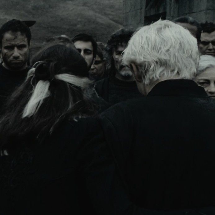 a group of people standing next to each other in front of a building with white hair