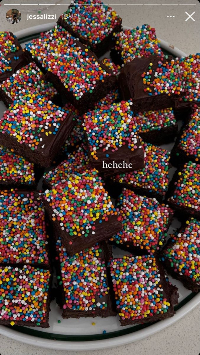 a plate filled with chocolate and sprinkles on top of a counter next to a cell phone