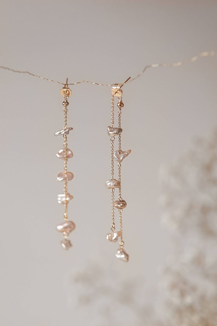 These handcrafted earrings feature two rows of Freshwater Pearls, each individually wrapped and suspended from a 14k 8cm gold-filled chain and secured with butterfly backings. Pair with the Safia necklace for a complete and coordinated look. Please note that, as we use only natural pearls, there may be slight variations in shape and shade. All our jewelry comes with a one-year guarantee valid from the date of delivery. Freshwater Pearl Earrings, Homemade Jewelry, Jewelry Lookbook, Pearl Earrings Dangle, Handcrafted Earrings, Bijoux Diy, Jewelry Inspo, Natural Pearls, Wire Jewelry