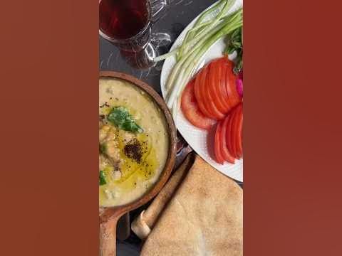 there is a bowl of soup and some vegetables on the table