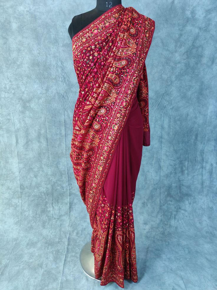 Kashmiri Embroidered Saree on Georgette with thread embroidery and some stones Fabric:  Georgette Length: 5.5 Meters | 6.1 yards Colour: Wine Blouse: Saree comes with blouse fabric. Base Color is same as Saree with border for sleeves or however you desire Please see product video for product details. If you have any questions message us anytime. Fall and Edging will be done complimentary.  Blouse Stitching (If Requested): Blouse will be stitched according to your measurements, which we will ask Thread Work Saree Embroidery, Transitional Pre-draped Saree With Intricate Embroidery, Pre-draped Saree With Intricate Embroidery, Art Silk Pre-draped Saree With Intricate Embroidery, Bollywood Blouse Piece With Intricate Embroidery For Transitional Season, Traditional Pre-draped Saree With Dori Work For Eid, Embroidered Dola Silk Choli For Traditional Ceremonies, Semi-stitched Pre-draped Saree With Intricate Embroidery, Embroidered Semi-stitched Choli With Traditional Drape