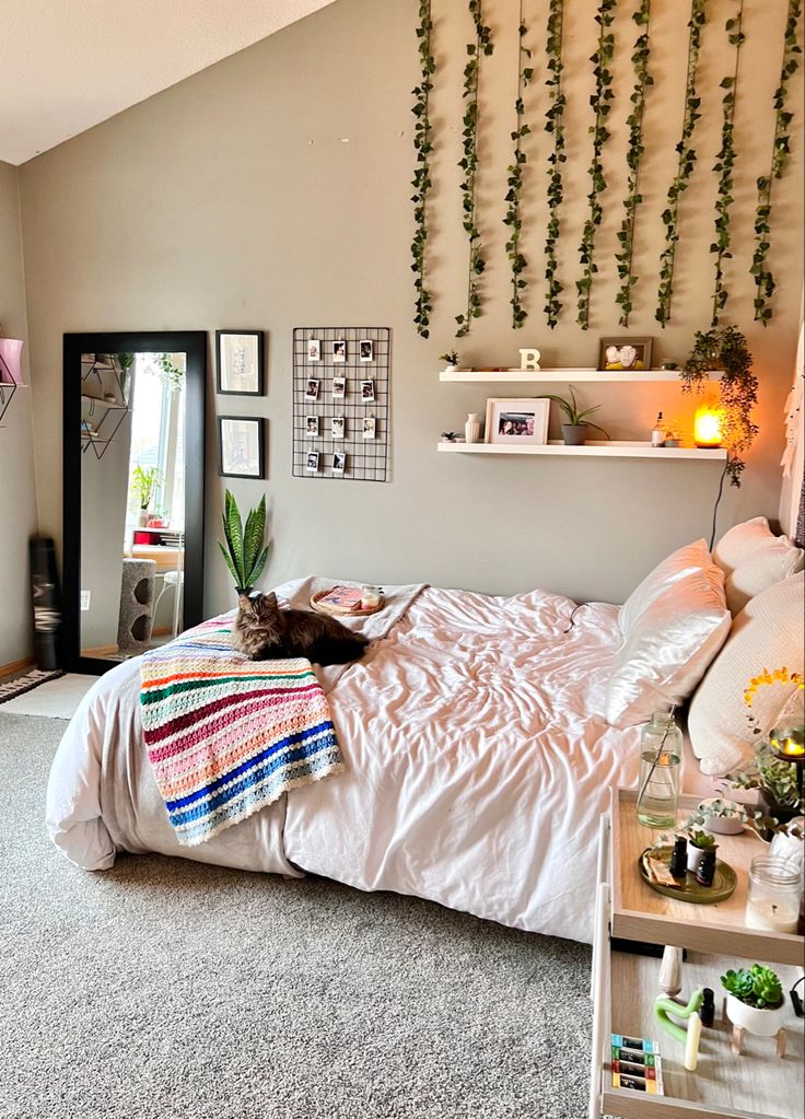 a cat laying on top of a bed in a bedroom