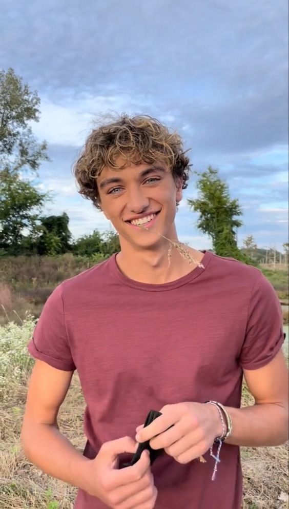 a young man is smiling and holding something in his hands