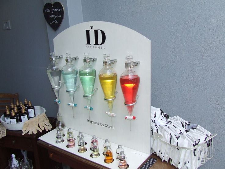 there are many bottles and glasses on the display table with each one being filled with liquid