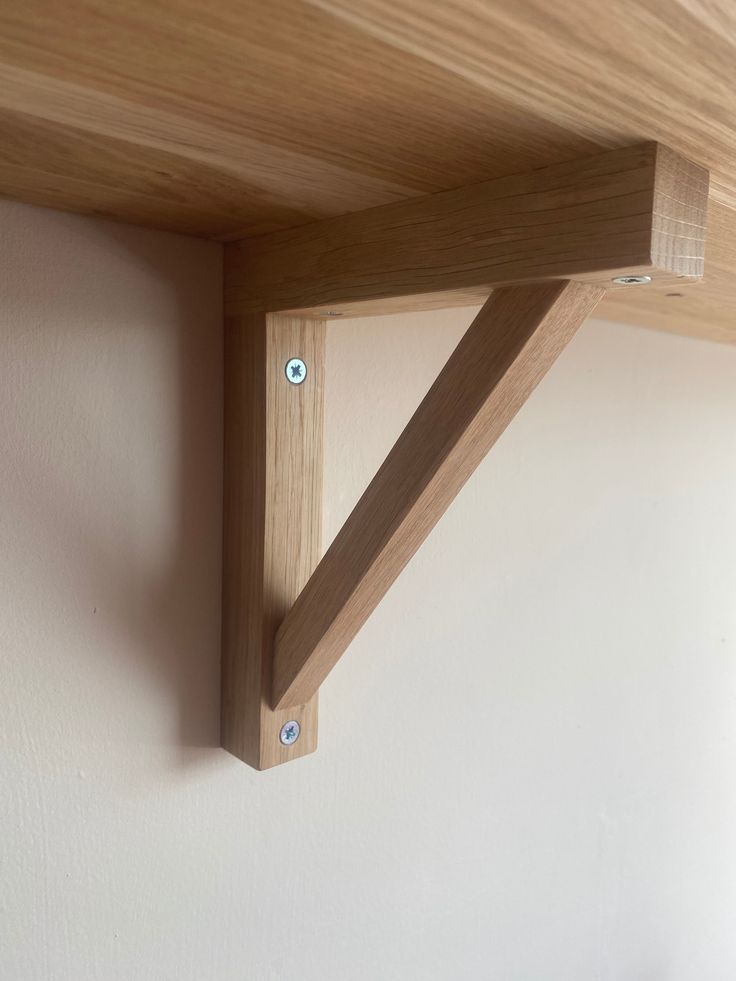 the corner of a wooden shelf with two screw holes