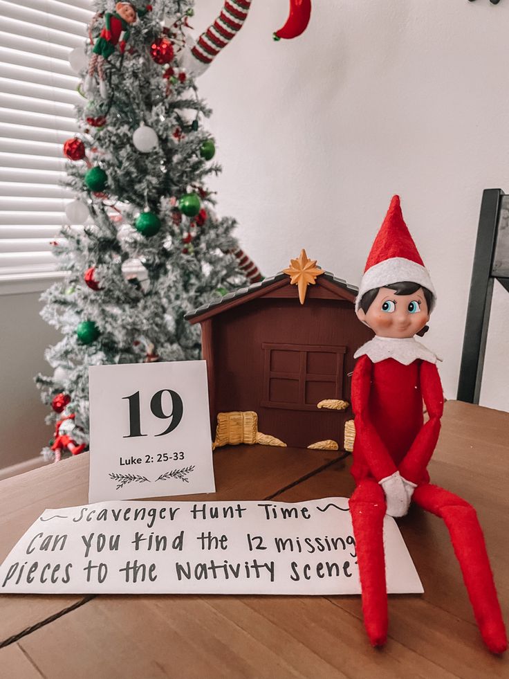 an elf is sitting on top of a table next to a sign that says 19