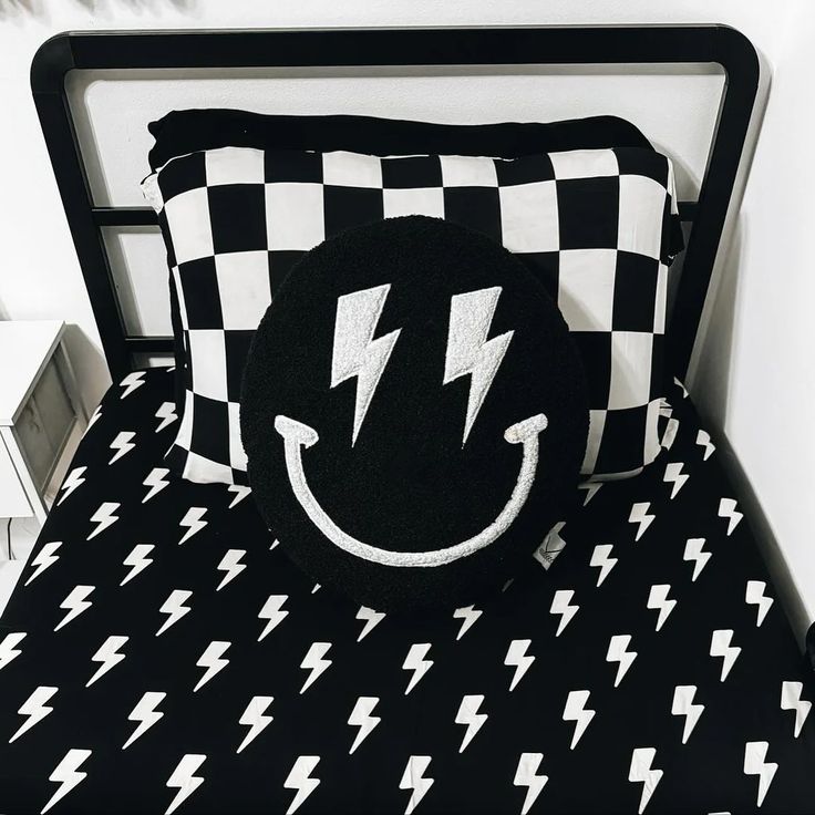 a black and white bed with lightning bolt pillows