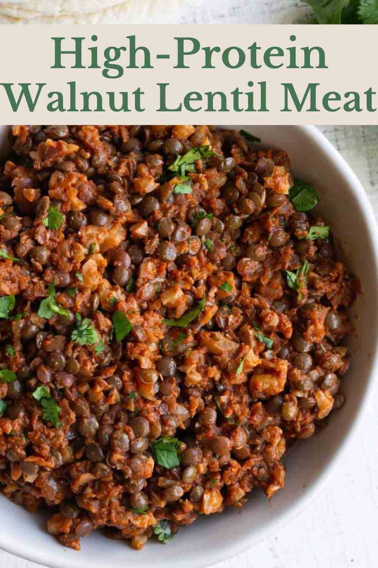 a white bowl filled with lentils and garnished with cilantro leaves