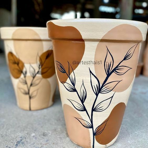 two flower pots with leaves painted on them