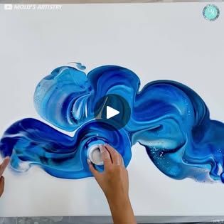 someone is painting an abstract blue and white artwork