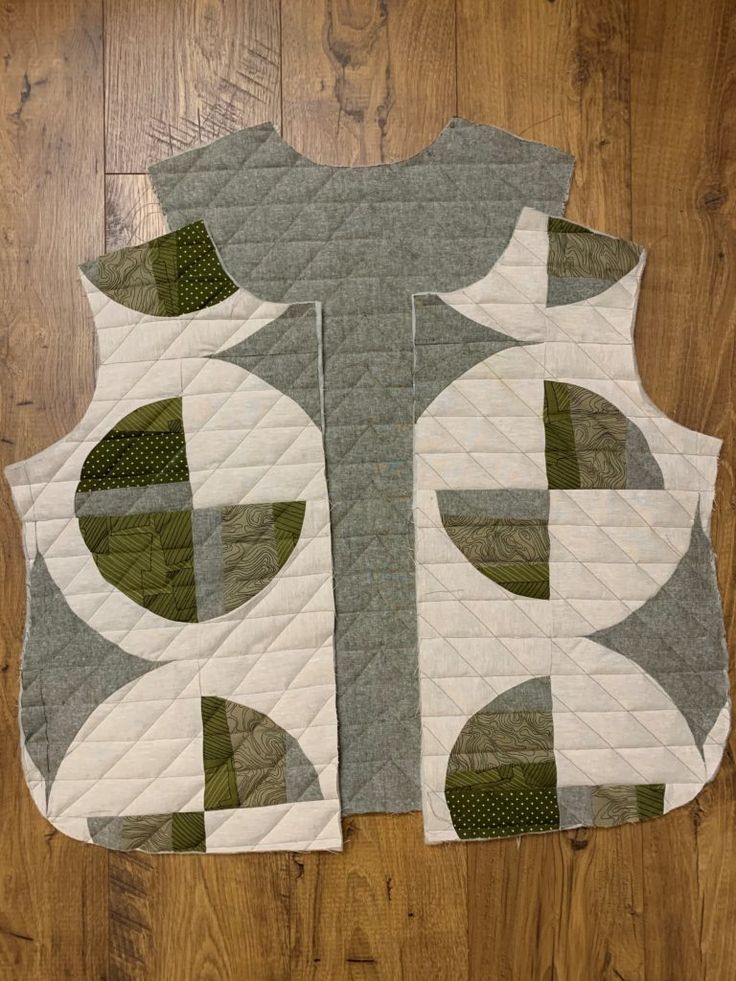 a quilted vest sitting on top of a wooden floor