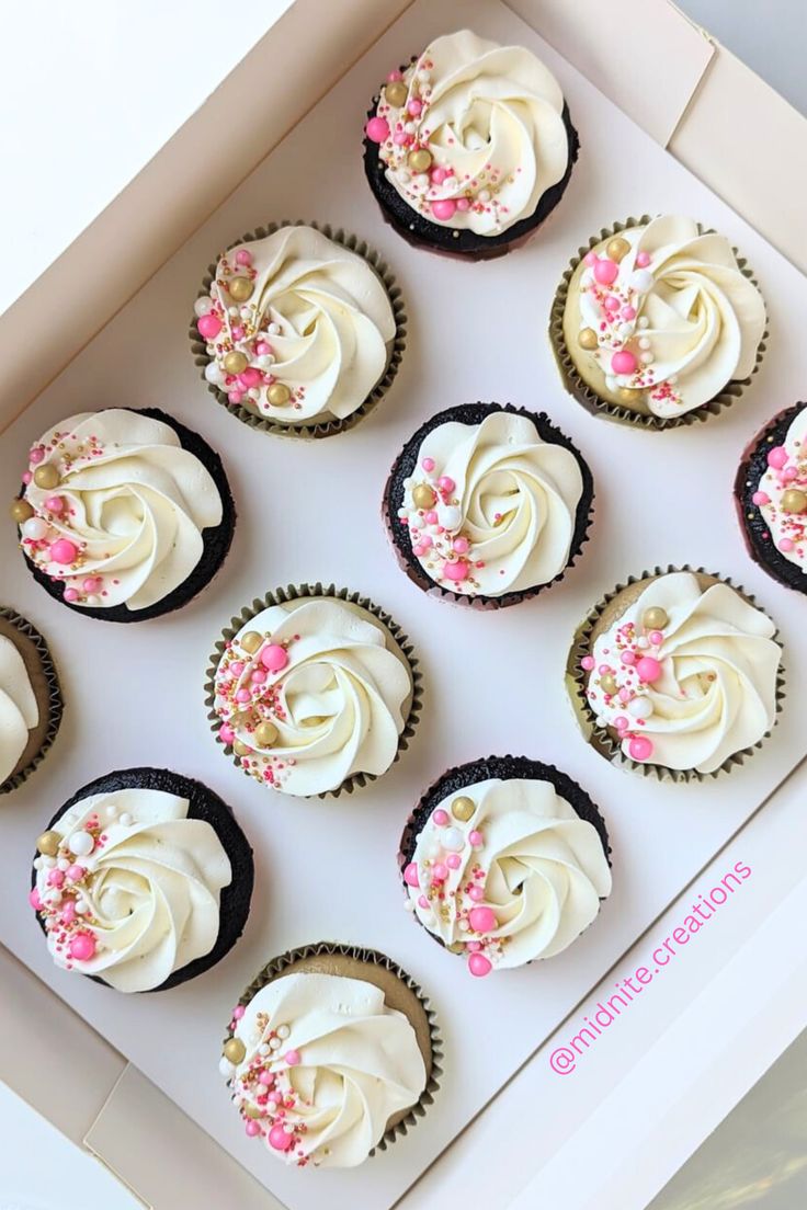 twelve cupcakes with white frosting and pink sprinkles