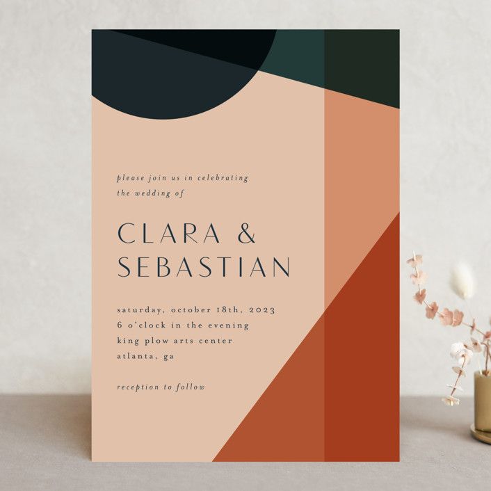 a wedding card with an orange, black and white geometric design on the front cover