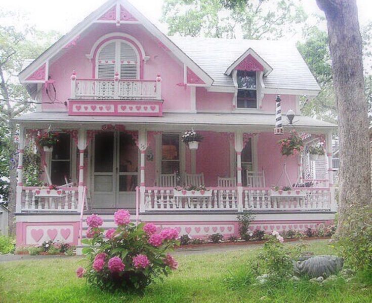 a pink house with white balconies and flowers